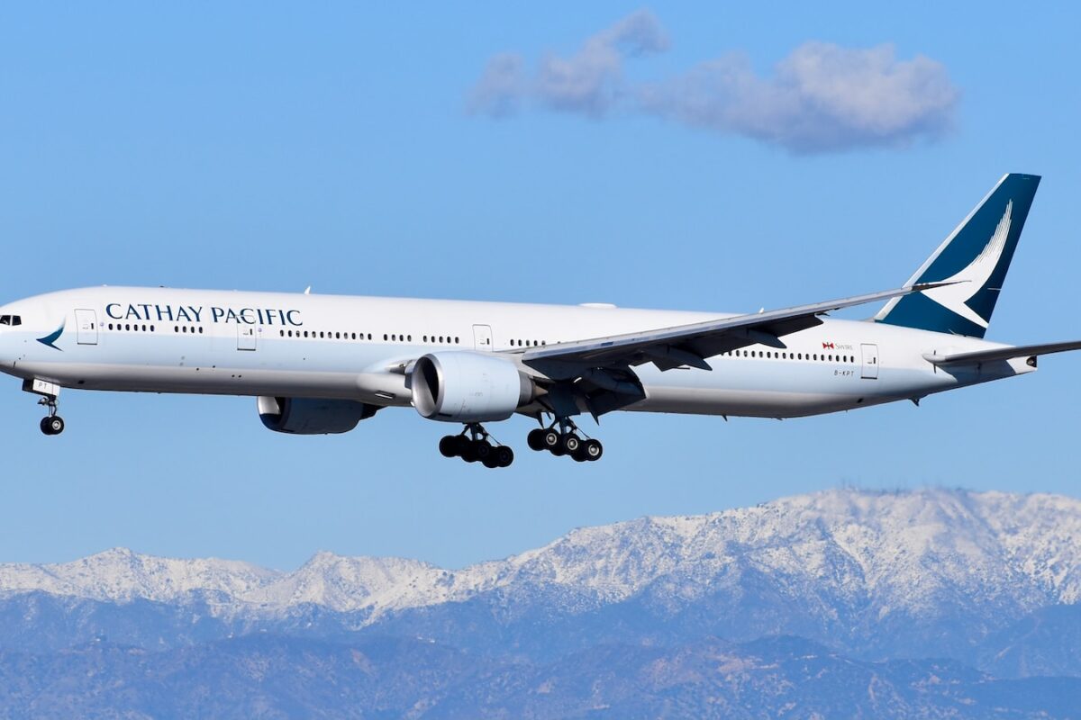 white passenger plane flying over snow covered mountain during daytime